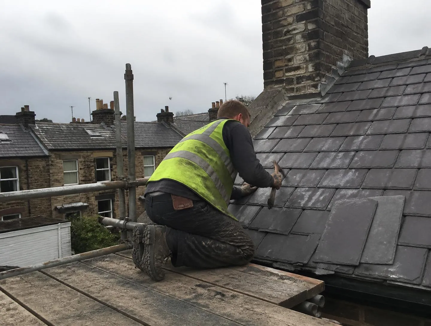 Roofer replacing slates on a Yorkshire terraced house